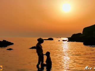 Párik sa miluje pri západe slnka